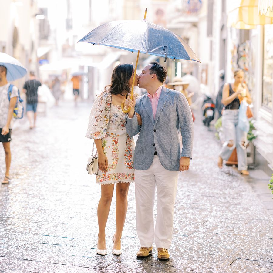 a couple kissing in the rain under an umbrella