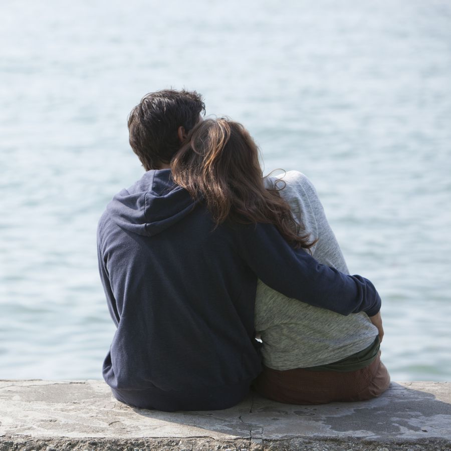 Young couple hugging outdoors by the sea
