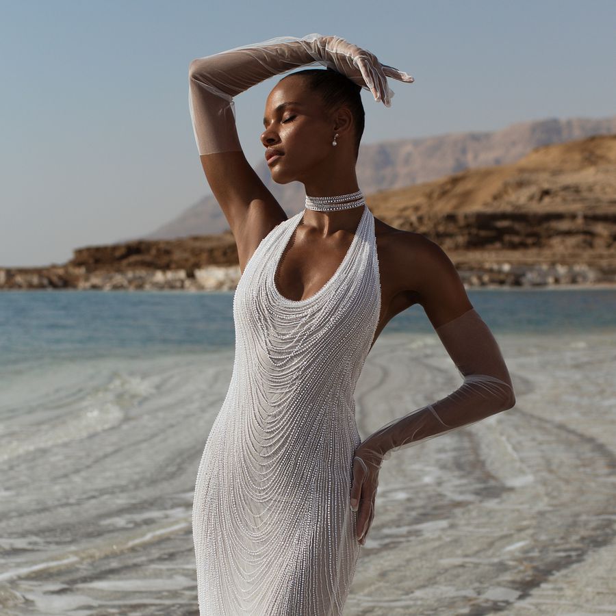 model wearing a pearl-encrusted halter-neck dress with tulle removable sleeves 