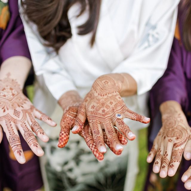 Bride with henna on her hands wearing an engagement ring