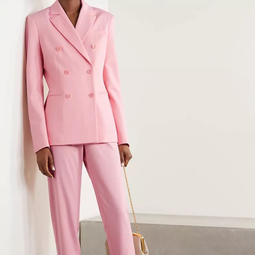 Mother-of-the-bride wearing a pink pantsuit in a cream-colored room